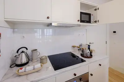 a kitchen with white cabinets and a counter top at BOUTIQUE Rentals-Flores Plaza in city historical center in Porto