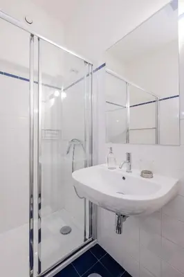 a white bathroom with a sink and a shower at BOUTIQUE Rentals-Flores Plaza in city historical center in Porto