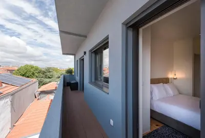 a balcony of a house with a bed and a window at LovelyStay - Gorgeous Modern Flat w/ Balcony in Porto