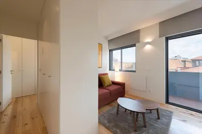 a living room with a red couch and a table at LovelyStay - Gorgeous Modern Flat w/ Balcony in Porto