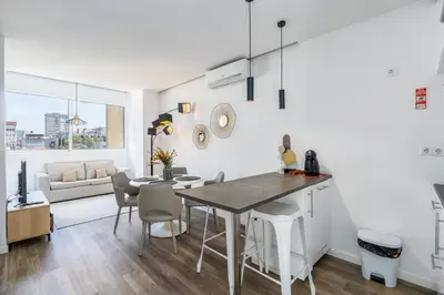 a kitchen and living room with a table and chairs at Angel Flats in Porto