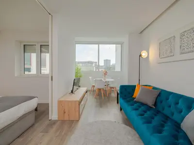 a living room with a blue couch and a table at Angel Flats in Porto