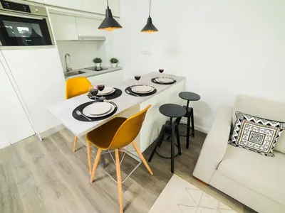a kitchen and living room with a table and chairs at Angel Flat in Porto
