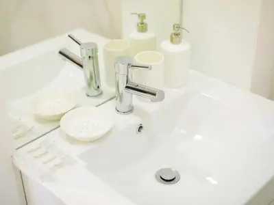a bathroom sink with two cups and a faucet at Angel Flat in Porto