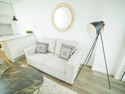 a living room with a white couch and a mirror at Angel Flat in Porto