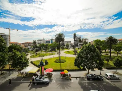 a view of a park with palm trees and cars at Angel Flat in Porto