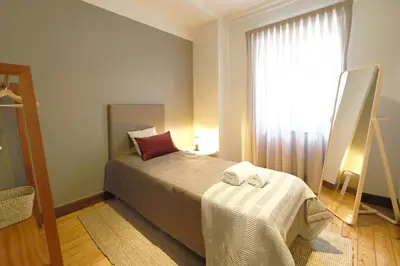 a small bedroom with a bed and a window at FLH Porto Spacious Flat in Porto