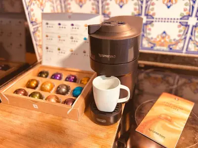 a coffee maker sitting next to a box of donuts at Apartamento Lar doce Lar Porto in Vila Nova de Gaia