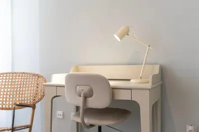 a white desk with a lamp and a chair at Marias River Apartment in Porto