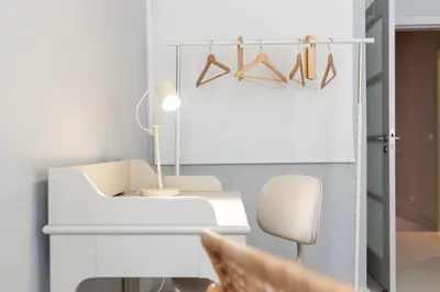 a desk with a lamp and a chair in a room at Marias River Apartment in Porto