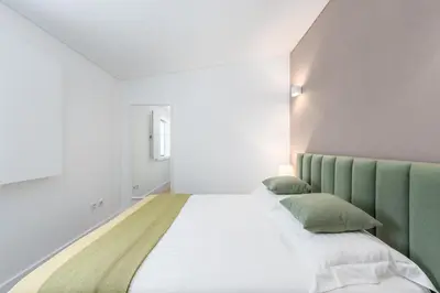a bedroom with two beds with green accents at Porto Belo Sao Bento Apartment in Porto