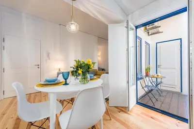 a white dining room with a white table and chairs at Porto Belo Sao Bento Apartment in Porto