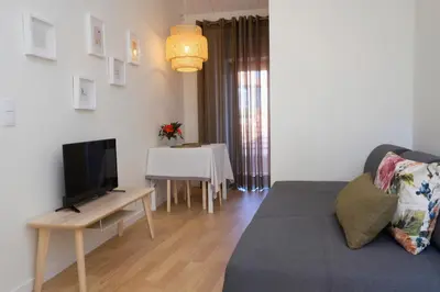 a living room with a table and a flat screen tv at Oporto Wall Apartments in Porto