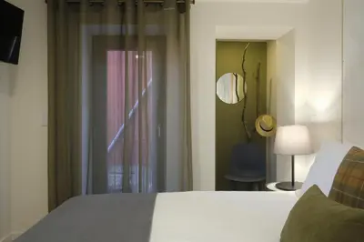 a bedroom with a bed and a window and a chair at Oporto Wall Apartments in Porto