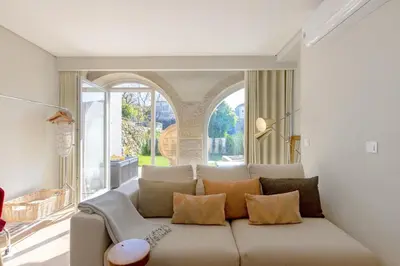 a living room with a couch and a large window at Boavista Garden Studio 183 in Porto