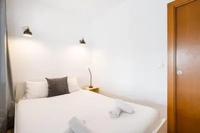 a bedroom with a white bed with two pillows at GuestReady - Paragon in Porto in Porto