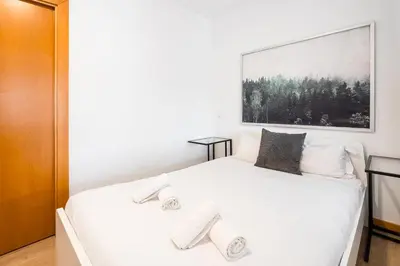 a bedroom with a white bed with a picture on the wall at GuestReady - Paragon in Porto in Porto