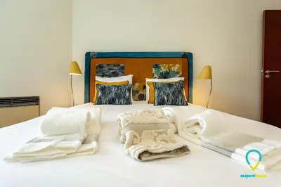 a bedroom with a bed with towels on it at Camilo Apartment in Porto