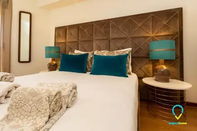 a bedroom with a large bed with blue pillows at Camilo Apartment in Porto