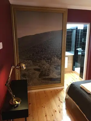 a bedroom with a large painting on the wall at Pimms Home Ribeira in Porto
