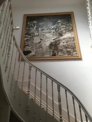 a painting hanging on a wall next to a staircase at Pimms Home Ribeira in Porto