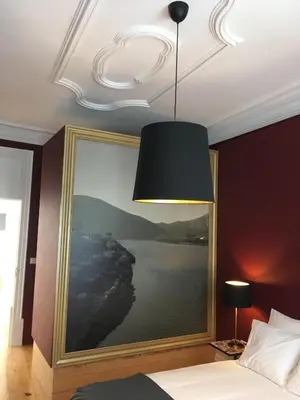 a bedroom with a large painting on the wall at Pimms Home Ribeira in Porto