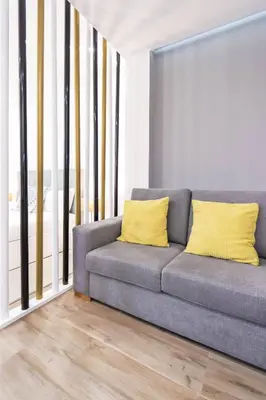 a gray couch with yellow pillows in a living room at HM - Nearby Bolhão Studio in Porto