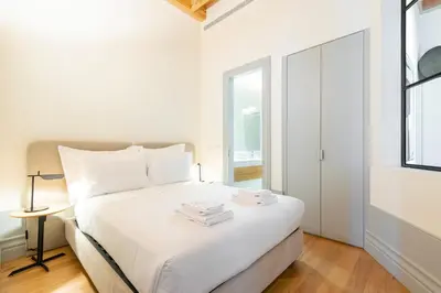 a white bedroom with a bed and a window at Mouzinho Village River in Porto