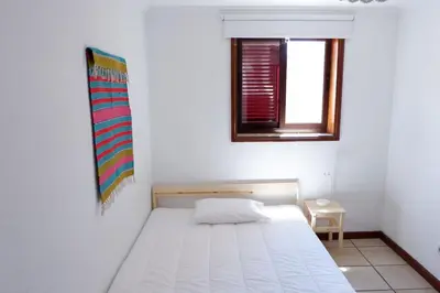 a small bedroom with a bed and a window at Kame House in Vila Nova de Gaia