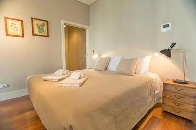 a bedroom with a large bed with two towels on it at Cardosas Square Apartments by Porto City Hosts in Porto