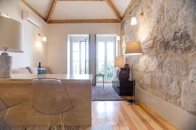 a room with a stone wall and a table and chairs at Picasso Suites Porto by PCH in Porto