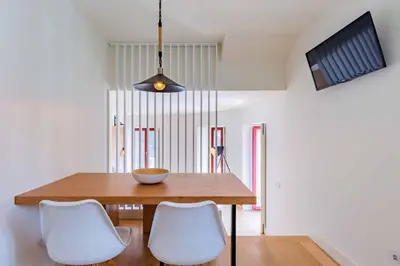 a dining room with a wooden table and white chairs at Lemago Porto Apartments - Sé in Porto