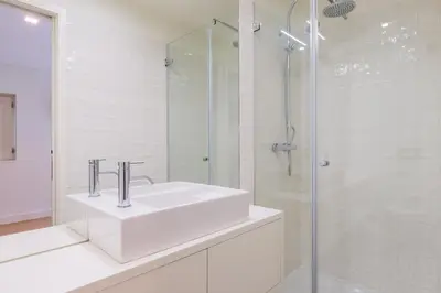 a white bathroom with a sink and a shower at Lemago Porto Apartments - Sé in Porto