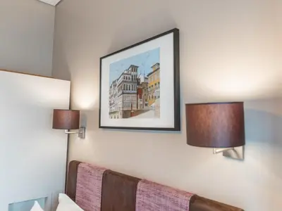 a bedroom with two lamps and a picture on the wall at Guest House Douro in Porto