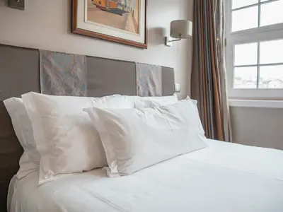 a bedroom with a white bed with white pillows at Guest House Douro in Porto