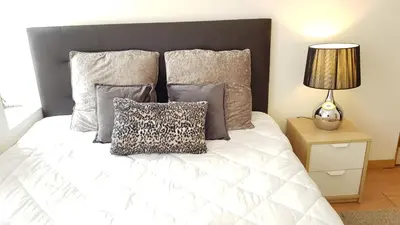 a bedroom with a white bed with pillows and a lamp at Oporto Beauty Flat in Porto