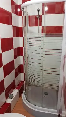 a shower in a bathroom with red and white checkered walls at Oporto Beauty Flat in Porto