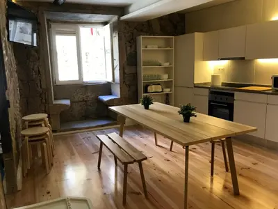 a kitchen with a table and chairs in a room at Onefam Ribeira in Porto