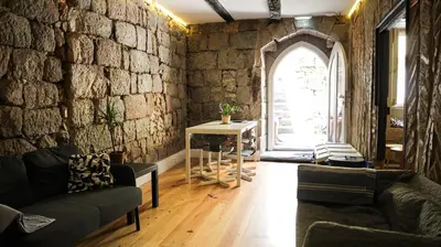 a living room with a stone wall at Onefam Ribeira in Porto
