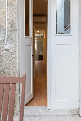 a white door with a bench in a hallway at ZD Moreira Flats A By PortoProperties4You in Porto