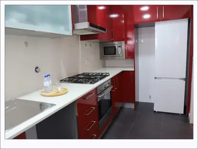 a kitchen with red cabinets and a stove top oven at Stay In Apartments - D. Hugo 23 in Porto