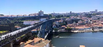 a bridge over a river with a boat on it at Stay In Apartments - D. Hugo 23 in Porto