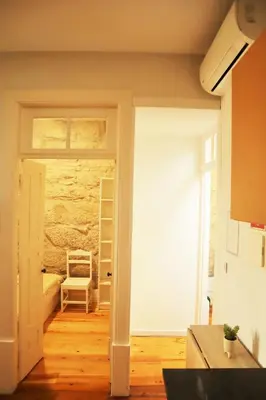 a room with a door leading to a room with a chair at ZD Moreira Flats E By PortoProperties4You in Porto
