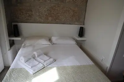 a white bed with two towels on top of it at ZD Moreira Flats E By PortoProperties4You in Porto