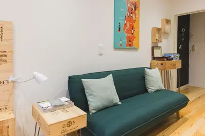 a living room with a green couch and a table at APOSENTUS - The Wine Studio in Porto
