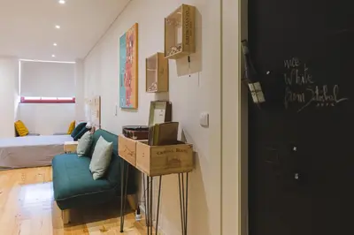 a living room with a blue couch and a bed at APOSENTUS - The Wine Studio in Porto
