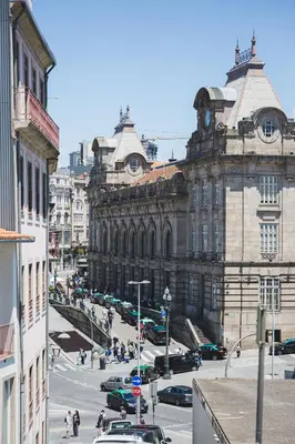 an old building with a clock tower in a city at APOSENTUS - The Wine Studio in Porto