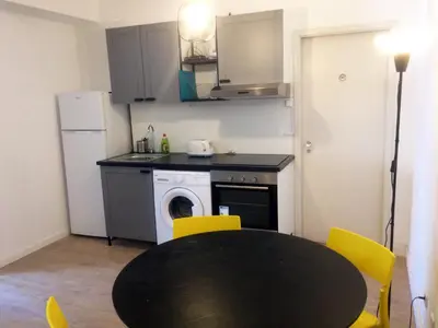 a kitchen with a black table and yellow chairs at Camões Lookout in Porto