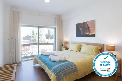 a bedroom with a large bed and a balcony at Host Wise - Annas Flats II in Vila Nova de Gaia