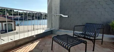 a bench sitting on a balcony looking out at the water at Oporto Serviced Apartments - Miragaia in Porto